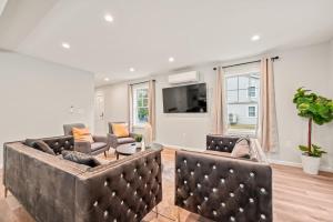 a living room with two couches and a tv at Spacious House with King Beds in Prime Location in Bloomfield