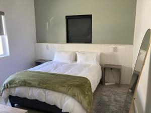 a bedroom with a bed with a television on the wall at The Villa On Fontana in Yzerfontein