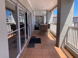 a balcony of a house with a table and chairs at The Villa On Fontana in Yzerfontein