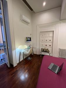 a living room with a laptop on a purple rug at Donnalbina 7 The Fresh BB in Naples