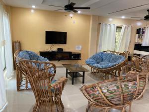 a living room with chairs and a flat screen tv at Amami Beachfront Bungalows & Villa in Puerto Galera