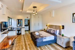 a bedroom with a bed and a desk in it at Van Gogh in Ballito +7 photos