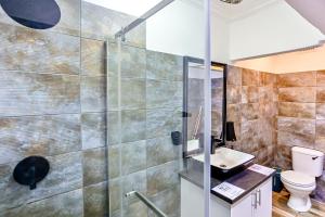 a bathroom with a shower and a toilet and a sink at Van Gogh in Ballito