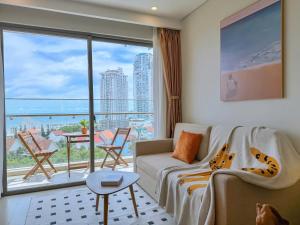 a living room with a couch and a large window at The Song Apartment 5 Stars Vung Tau - Căn Hộ Du Lịch 5 Sao Cạnh Biển - DUMIN HOMESTAY in Vung Tau