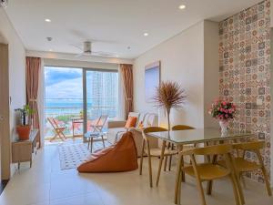 a living room with a table and chairs with a view at The Song Apartment 5 Stars Vung Tau - Căn Hộ Du Lịch 5 Sao Cạnh Biển - DUMIN HOMESTAY in Vung Tau