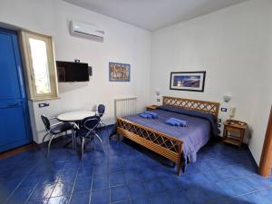 a bedroom with a bed and a table and a window at Al Baglio in Mondello