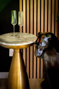 Ein Hund sitzt neben einem Tisch mit zwei Weingläsern in der Unterkunft Love Room The perfect accommodation for a romantic getaway cozy and intim in Sotteville-lès-Rouen + 14 Fotos