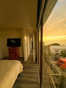 Una habitación con cama y vistas al océano. en Cabañas del Sol, en La Boca