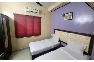 a small room with two beds and a window at Via Blue Moon Residency in Chennai +11 photos