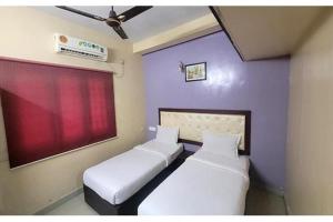two beds in a room with purple walls at Via Blue Moon Residency in Chennai