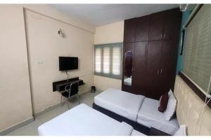 a room with a bed and a tv in it at Via Blue Moon Residency in Chennai