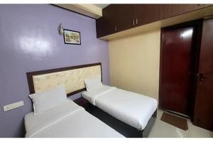 a small room with two beds and a door at Via Blue Moon Residency in Chennai