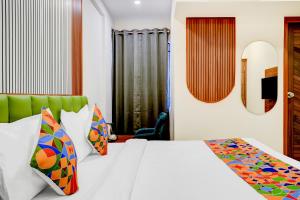 a bedroom with a white bed with colorful pillows at FabHotel Leon Square in Bengaluru +22 photos