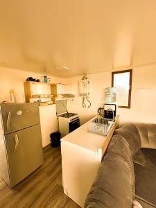 cocina pequeña con sofá y nevera en Cabañas del Sol, en La Boca 11 fotos más