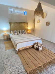 Un dormitorio con una cama grande y una alfombra grande. en Dar Minel- Deine Wohlfühloase mit Garten und Sonnenterasse, en Zaouit Massa