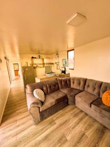 una sala de estar con un sofá marrón en una habitación en Cabañas del Sol, en La Boca