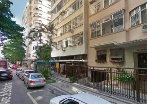una calle con coches estacionados frente a un edificio en Apartamento Vista Parcial Mar, en Río de Janeiro