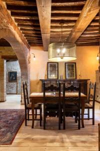 ein Esszimmer mit einem Holztisch und einem Kronleuchter in der Unterkunft 16th Century Townhouse, Large Garden Near Lake, Tuscany and Umbria - Sleeps 18 in Gioiella