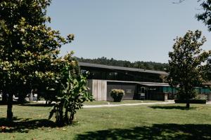 a large black building with trees in front of it at Pazo Almuzara in Boborás