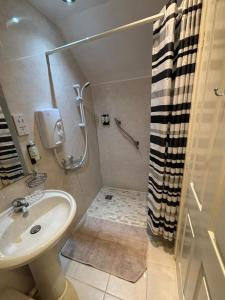 a bathroom with a sink and a shower at Squirrel View Cottage B&B in Buckenham