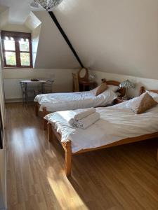 a room with two beds and a table with a window at Squirrel View Cottage B&B in Buckenham
