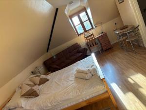 an attic bedroom with a bed and a couch at Squirrel View Cottage B&B in Buckenham