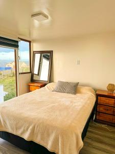 Un dormitorio con una cama grande y una ventana en Cabañas del Sol, en La Boca