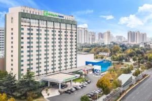 an aerial view of a hotel building with a parking lot at Holiday Inn Express Zhengzhou Zhongzhou by IHG in Zhengzhou