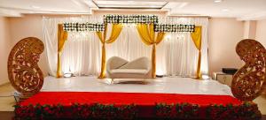 Una habitación con una cama y una silla y cortinas. en RR Grand Inn, en Coimbatore 18 fotos más