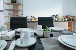 Una mesa de comedor con platos y utensilios blancos sobre ella. en Apart'hotel Assomada, en Assomada