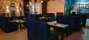 Un comedor con mesas y sillas azules. en RR Grand Inn, en Coimbatore