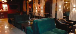 un vestíbulo con sofás y sillas y un bar en RR Grand Inn, en Coimbatore