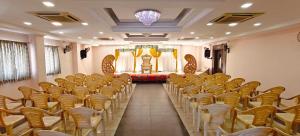 Una habitación con filas de sillas y una lámpara de araña. en RR Grand Inn, en Coimbatore