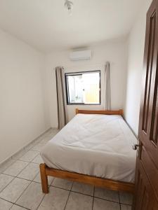 a bedroom with a bed and a window at Casa com ar-condicionado no centro da cidade, bem localizada, 10min da praia a pé in Prado
