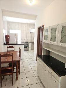 a kitchen with a table and a dining room at Casa com ar-condicionado no centro da cidade, bem localizada, 10min da praia a pé in Prado