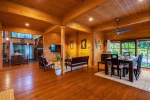 ein Esszimmer und Wohnzimmer einer Blockhütte in der Unterkunft amã Stays & Trails The Malabar Villa Heliconia, Kozhikode in Wayanad