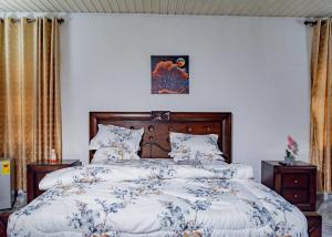 een slaapkamer met een bed met een blauw en wit dekbed bij The Victory Residence in Accra