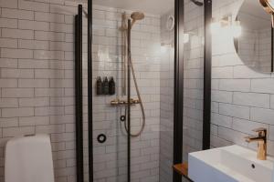 a bathroom with a shower with a toilet and a sink at Home Hotel Packhuset in Kalmar +84 photos