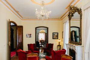 a living room with red chairs and a mirror at Pazo Almuzara in Boborás