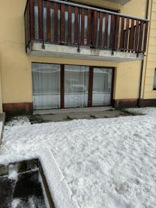 a building with a balcony with snow in front of it at Leo Loft - Pool, Sauna & Free Parking in San Bernardino
