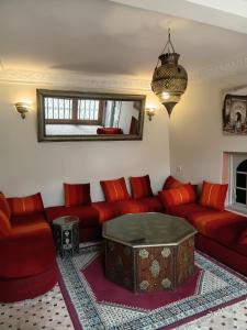 a living room with a red couch and a table at Riad Le Bijou de Zahra Marrakech Kasbah in Marrakech