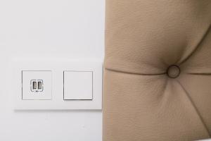 un interruptor de luz con un reloj al lado de la cama en Apart'hotel Assomada, en Assomada