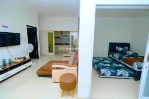 una sala de estar con un sofá y una cama en Ivo Homestay Jogja, en Gondowulung