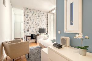 a living room with a white couch and a chair at Downtown Riverside by Homing in Lisbon