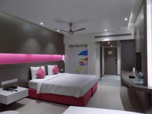 a bedroom with a large bed and a desk at ZIBE Coimbatore by GRT Hotels in Coimbatore +17 photos