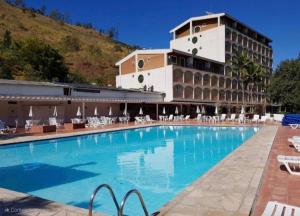un hotel con piscina frente a un edificio en Cavalinho Branco 305 suíte com varanda, en Águas de Lindóia