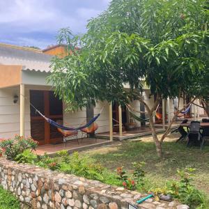 a house with a hammock in front of it at Hostal La Cabaña Tayrona in Santa Marta