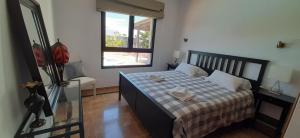 een slaapkamer met een bed met een geruite deken bij Villa Adais in Playa Blanca +21 foto's