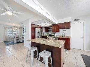 a kitchen with a large island with two stools at Largo Pool House Firepit Pet Friendly in Largo