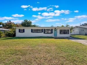a white house with a blue door and a yard at Largo Pool House Firepit Pet Friendly in Largo